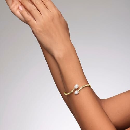 Arm wearing a gold bracelet with pearls