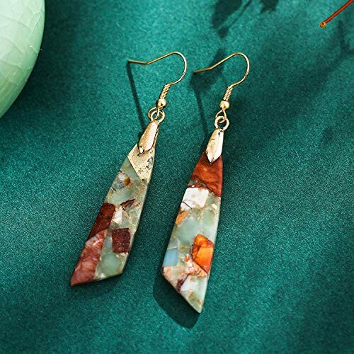 Colorful mosaic stone earrings on a green background.