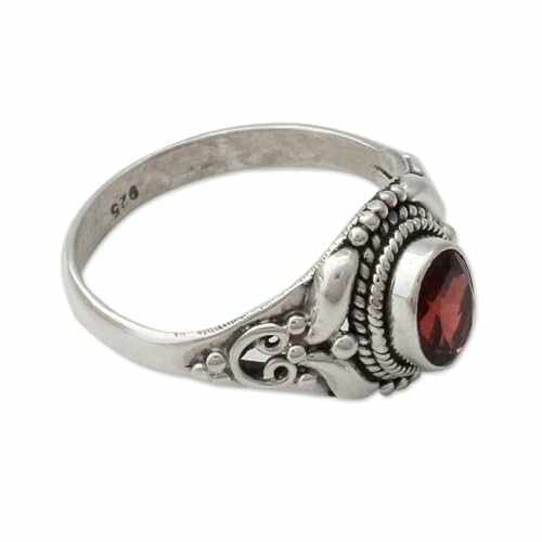 Intricate silver ring with a red garnet gemstone