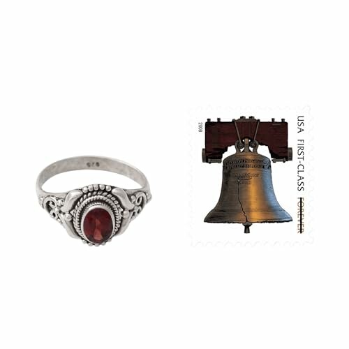 Silver ring with a red gemstone next to a Liberty Bell stamp.