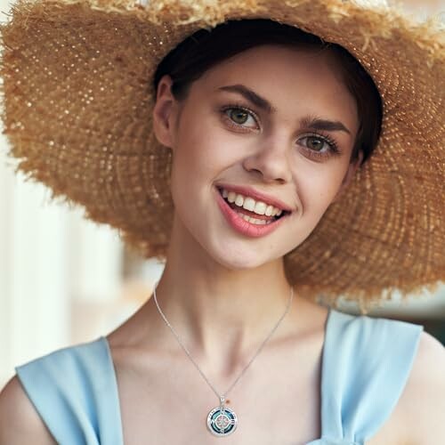 Woman smiling in a straw hat and blue dress