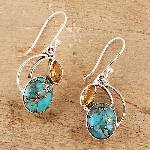 Turquoise and citrine silver earrings on wooden surface