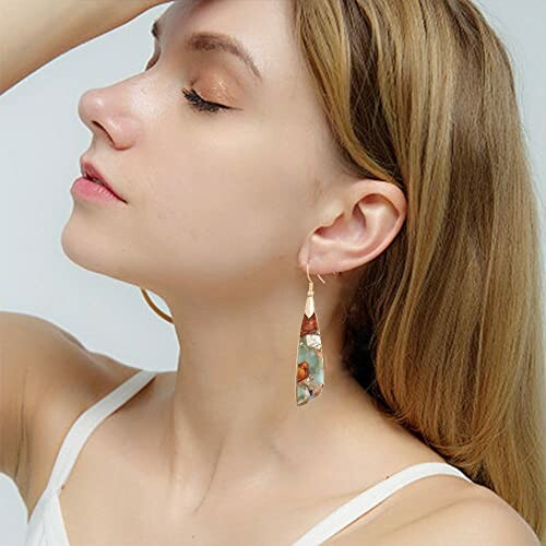 Woman wearing colorful earrings with a side profile view.